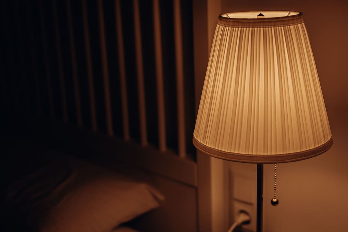 Éclairage tamisé et textiles en lin dans une décoration chambre adulte