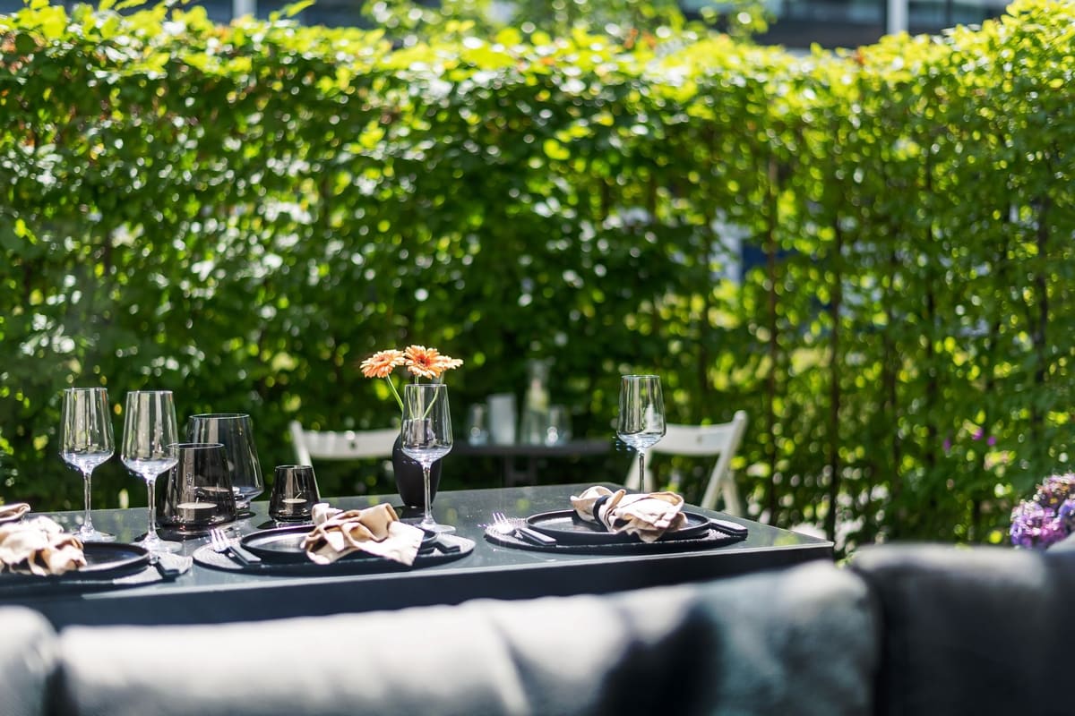 Salon de jardin repas six places en bois avec table dressée sur une terrasse